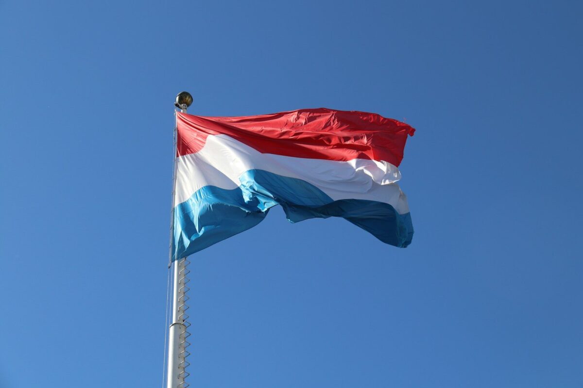 a red, white and blue flag flying in the wind